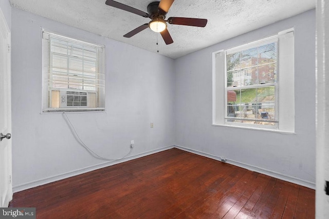 spare room featuring a ceiling fan, a textured ceiling, cooling unit, wood-type flooring, and baseboards