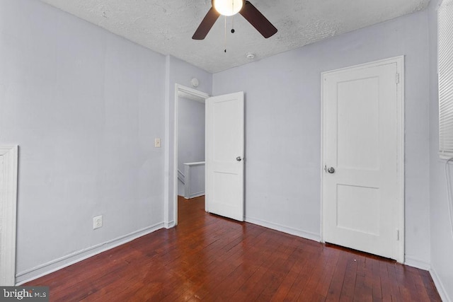 unfurnished bedroom with wood-type flooring, a textured ceiling, a ceiling fan, and baseboards
