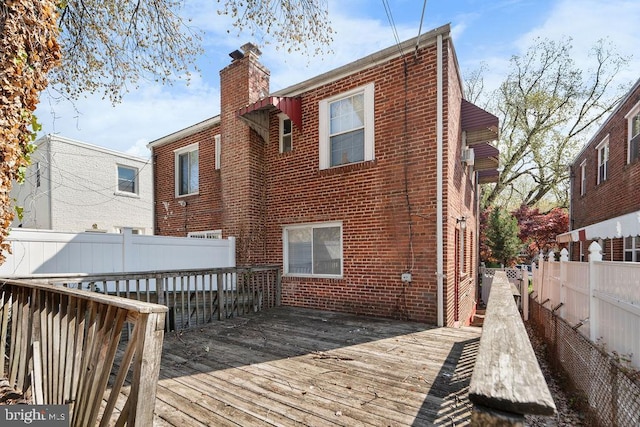 back of property featuring a wooden deck, brick siding, and fence