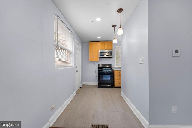 hallway featuring visible vents, baseboards, recessed lighting, and light wood-style floors