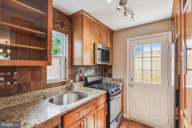 829 S Ivy St, Arlington, VA 22204 - kitchen with stainless steel appliances, backsplash, a sink, and brown cabinets