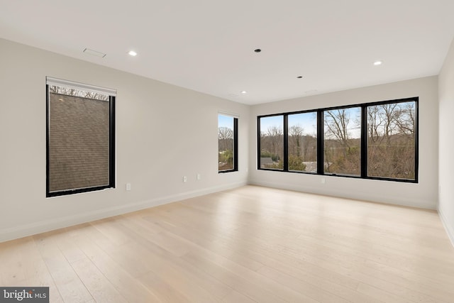spare room featuring recessed lighting, light wood-style floors, and baseboards