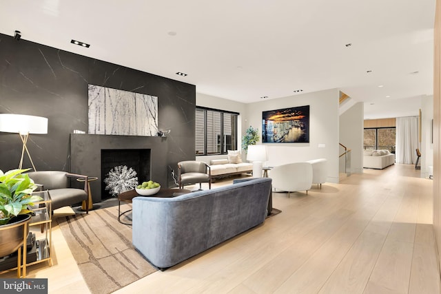 living area featuring light wood finished floors, a wealth of natural light, and a fireplace