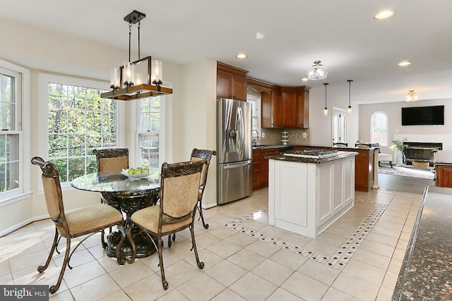 kitchen with stainless steel fridge, recessed lighting, open floor plan, backsplash, and pendant lighting