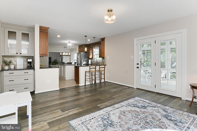 interior space featuring a peninsula, dark countertops, a notable chandelier, and dark wood-type flooring