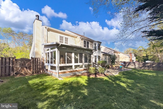 rear view of property with a sunroom, a fenced backyard, a gate, a chimney, and a yard