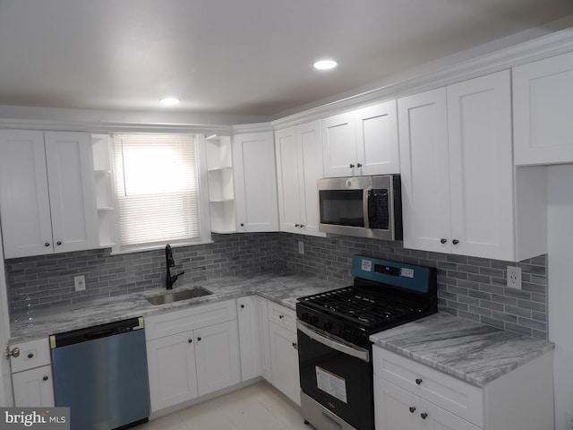 kitchen with a sink, stainless steel microwave, gas range oven, dishwashing machine, and open shelves