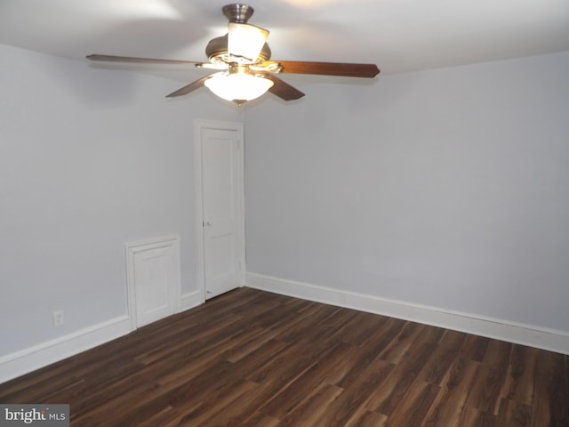 spare room featuring dark wood finished floors, baseboards, and a ceiling fan