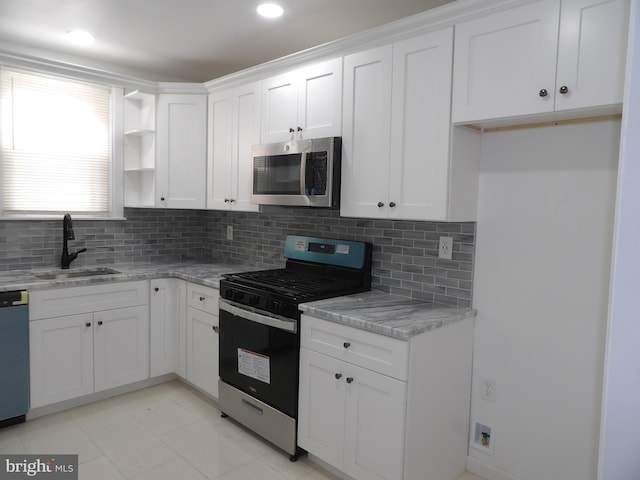 kitchen featuring range with gas cooktop, a sink, decorative backsplash, stainless steel microwave, and dishwashing machine