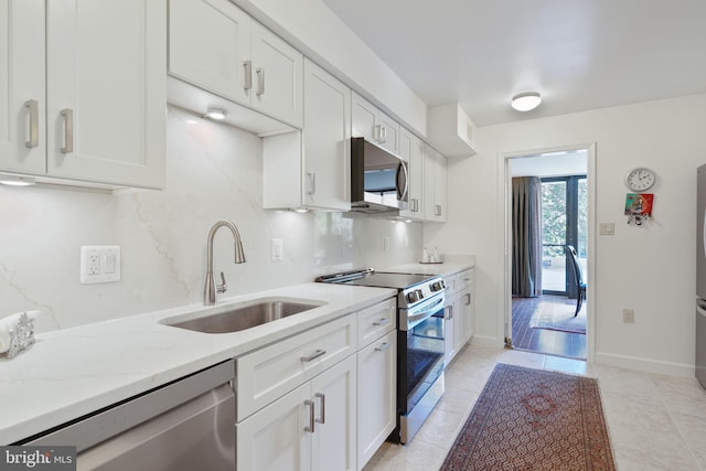 4200 Massachusetts Ave NW Unit 106, Washington, DC 20016 - kitchen with stainless steel appliances, a sink, white cabinetry, and light stone countertops