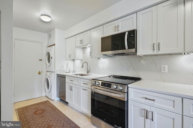 4200 Massachusetts Ave NW Unit 106, Washington, DC 20016 - kitchen featuring appliances with stainless steel finishes, stacked washer and clothes dryer, a sink, and white cabinetry