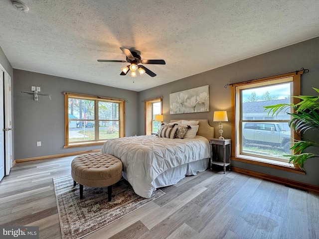 18855 Wicomico River Dr, Cobb Island, MD 20625 - bedroom featuring light wood-type flooring, a ceiling fan, baseboards, and a textured ceiling