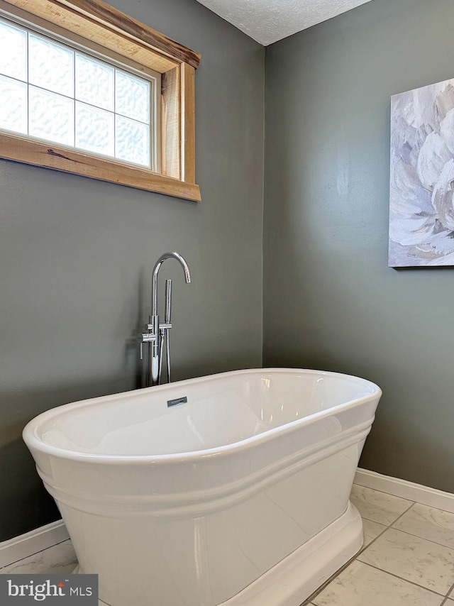 18855 Wicomico River Dr, Cobb Island, MD 20625 - bathroom with a soaking tub, baseboards, marble finish floor, and a sink