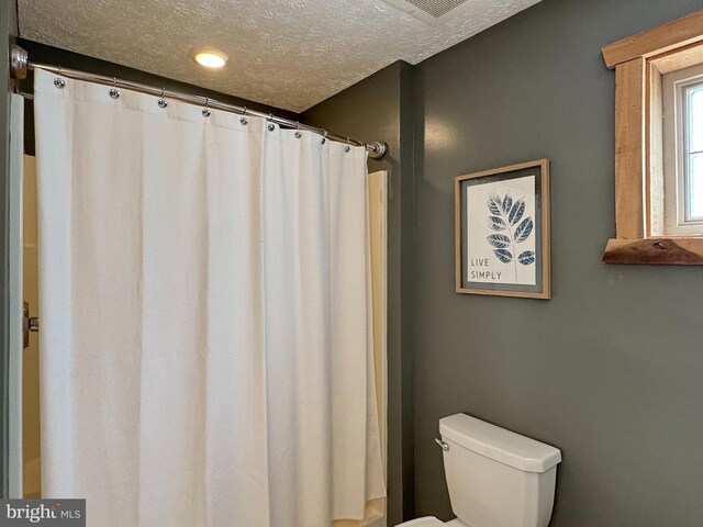 18855 Wicomico River Dr, Cobb Island, MD 20625 - full bath with curtained shower, a textured ceiling, and toilet