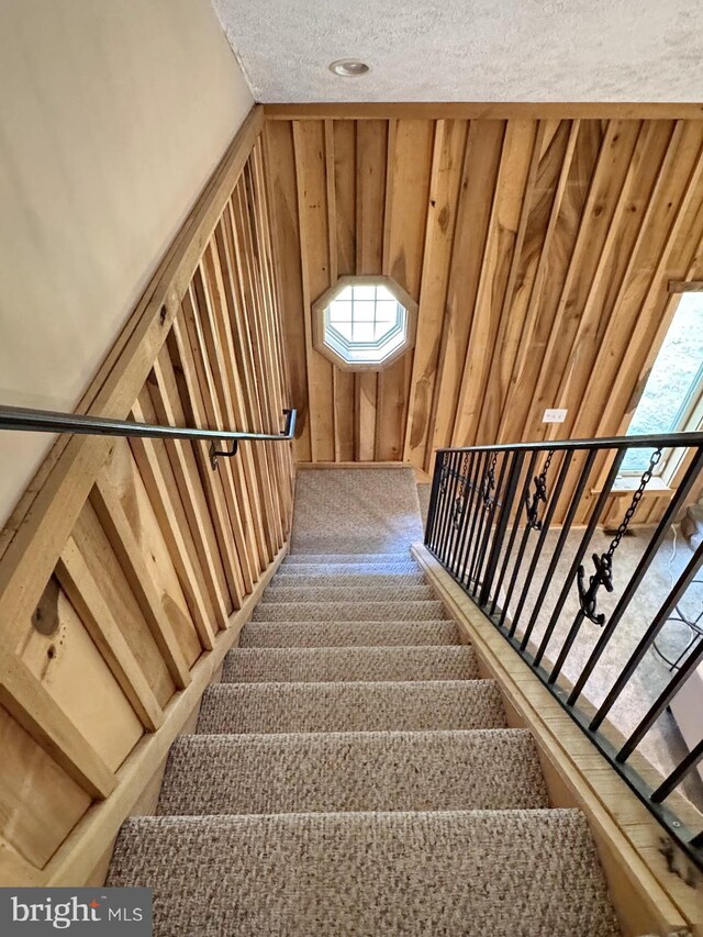 18855 Wicomico River Dr, Cobb Island, MD 20625 - staircase featuring wooden walls and a textured ceiling