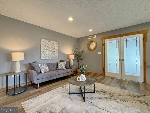 18855 Wicomico River Dr, Cobb Island, MD 20625 - living area featuring wood finished floors, a textured ceiling, french doors, baseboards, and visible vents