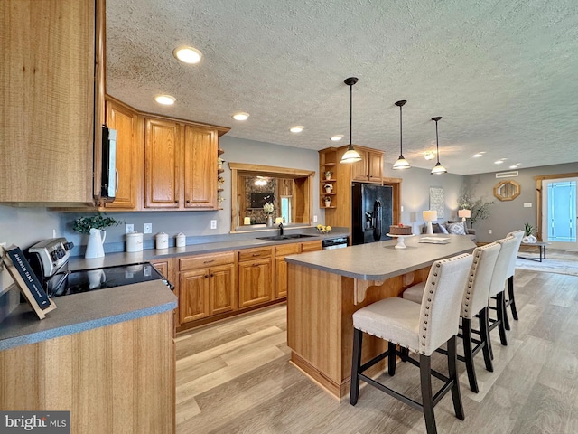 18855 Wicomico River Dr, Cobb Island, MD 20625 - kitchen featuring stainless steel appliances, light wood-style flooring, a sink, a textured ceiling, and open shelves