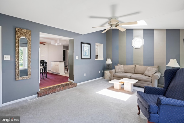 carpeted living room with ceiling fan and baseboards