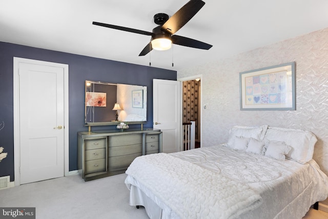 bedroom with wallpapered walls, carpet floors, and a ceiling fan