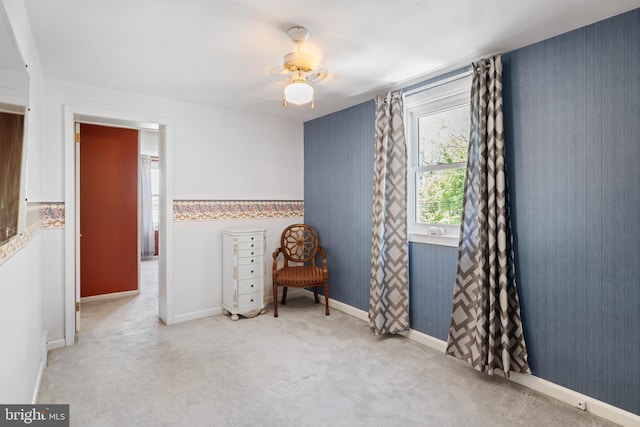 unfurnished room featuring carpet, baseboards, and a ceiling fan