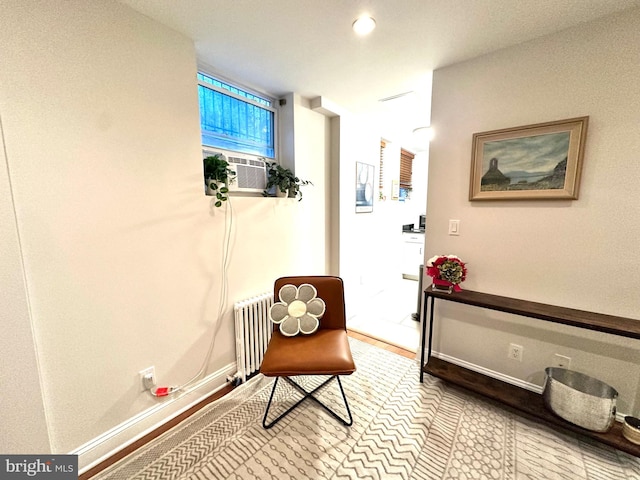 hallway with cooling unit, radiator, and baseboards