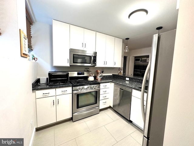kitchen featuring pendant lighting, light tile patterned floors, white cabinets, stainless steel appliances, and a toaster
