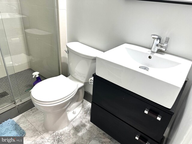 bathroom featuring toilet, a stall shower, and vanity