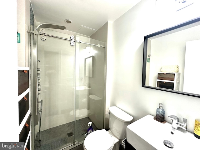full bathroom featuring a shower stall, a sink, and toilet