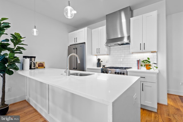 1169 Neal St NE Unit 1, Washington, DC 20002 - kitchen with a peninsula, wall chimney exhaust hood, tasteful backsplash, high end refrigerator, and light wood-style flooring