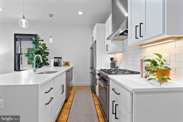 1169 Neal St NE Unit 1, Washington, DC 20002 - kitchen with wall chimney range hood, a sink, a peninsula, light wood-type flooring, and premium appliances