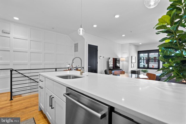 1169 Neal St NE Unit 1, Washington, DC 20002 - kitchen featuring hanging light fixtures, dishwasher, a sink, light countertops, and white cabinets