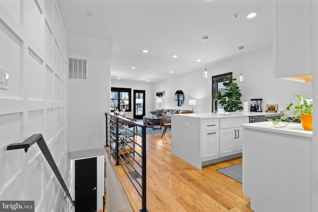 1169 Neal St NE Unit 1, Washington, DC 20002 - kitchen with visible vents, light wood-style floors, light countertops, white cabinetry, and a sink