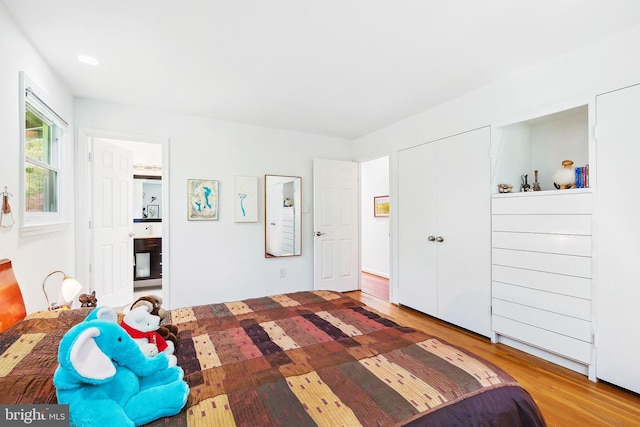 bedroom featuring connected bathroom and wood finished floors