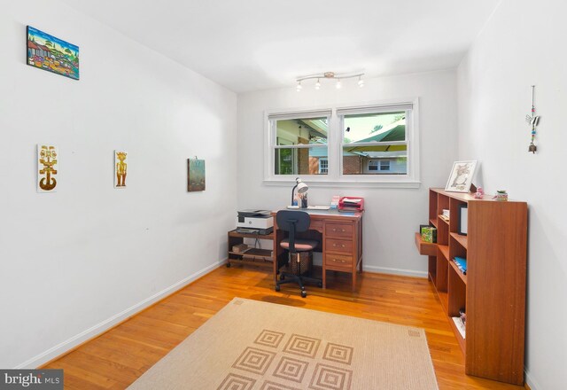 home office with baseboards and wood finished floors