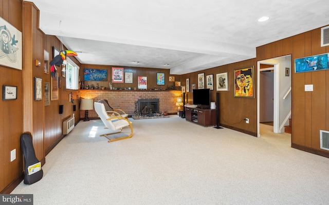 living area featuring carpet floors, baseboards, wood walls, and visible vents