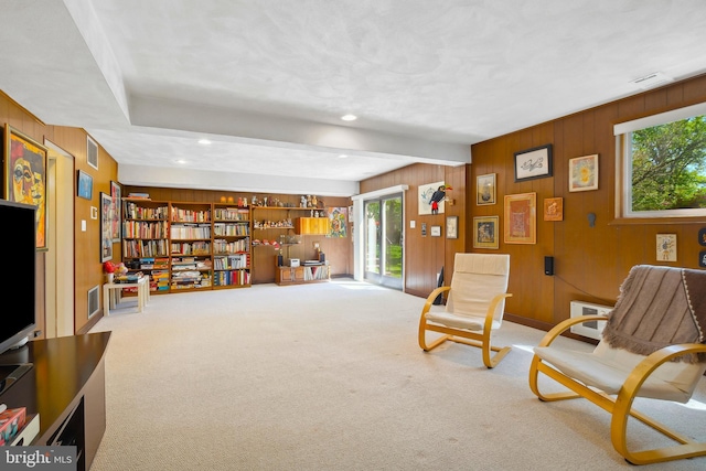 living area with wooden walls, carpet flooring, recessed lighting, and visible vents