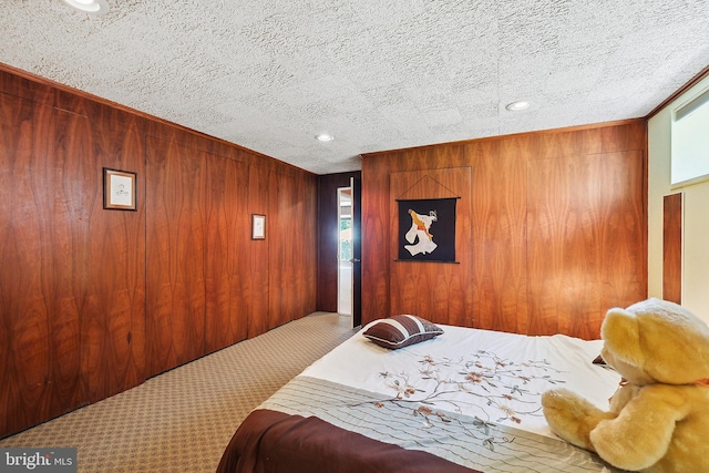 carpeted bedroom with recessed lighting, a textured ceiling, and wooden walls