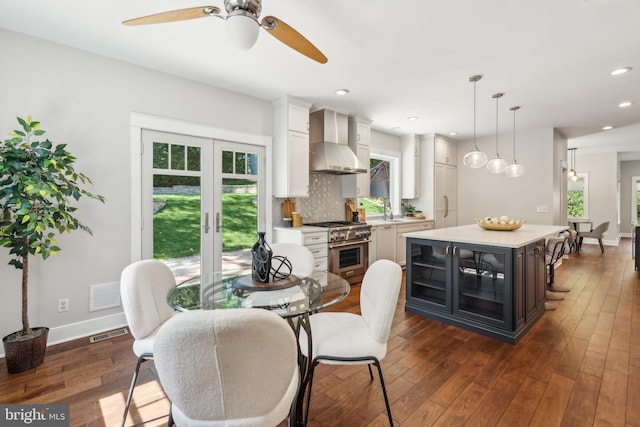 dining area with visible vents, dark wood finished floors, ceiling fan, and baseboards