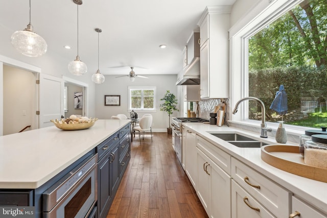 kitchen with dark wood-style flooring, light countertops, white cabinetry, a sink, and stainless steel appliances