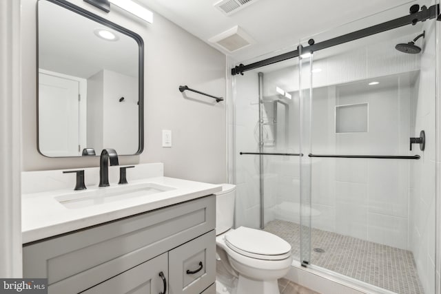 full bathroom featuring vanity, a shower stall, toilet, and visible vents