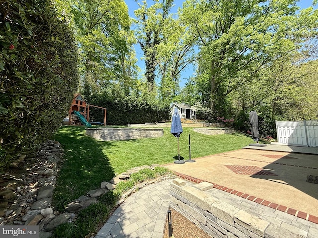 view of yard with a patio, a playground, and an outbuilding