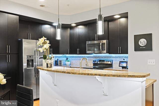 14184 Haro Trl, Gainesville, VA 20155 - kitchen featuring stainless steel appliances, dark cabinetry, a kitchen bar, and visible vents