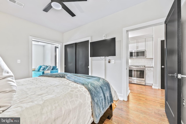 bedroom with ceiling fan, a closet, light wood finished floors, and visible vents