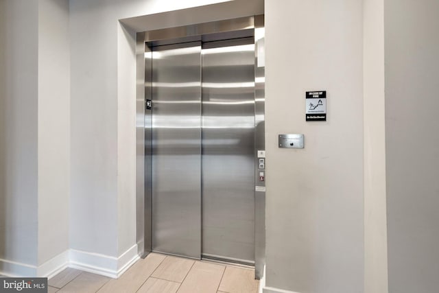 interior space featuring elevator and baseboards