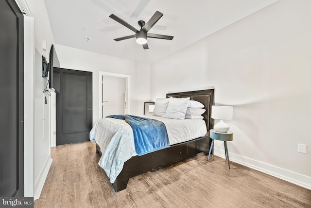 bedroom with a ceiling fan, baseboards, and wood finished floors