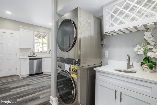 washroom featuring stacked washer / drying machine, wood finished floors, recessed lighting, and a sink