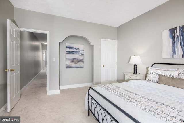 bedroom with light colored carpet and baseboards