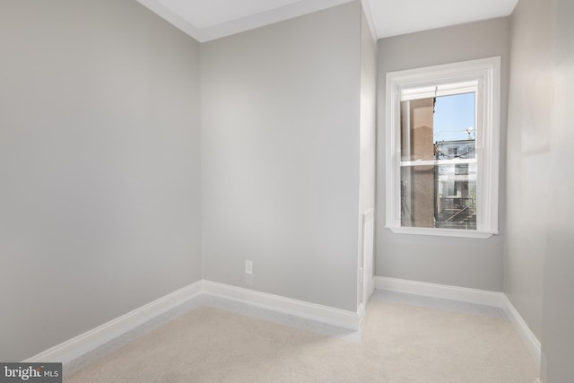 empty room featuring baseboards and light colored carpet