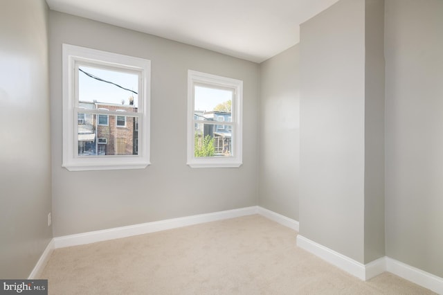 unfurnished room featuring baseboards and light colored carpet