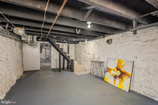 unfinished basement featuring stairs